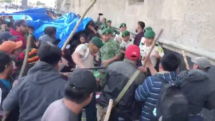 Agreden manifestantes con palos a policías; tienen orden de no responder 