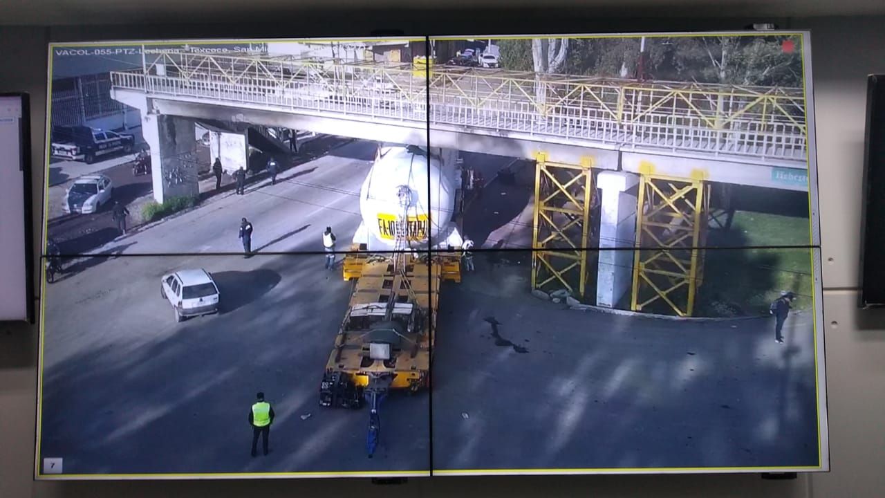 Grúa se atora en puente peatonal en Acolman y conductor rompe el concreto del puente con martillo 